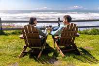 A couple toasting wine glasses on the bluff at Kalaloch Lodge