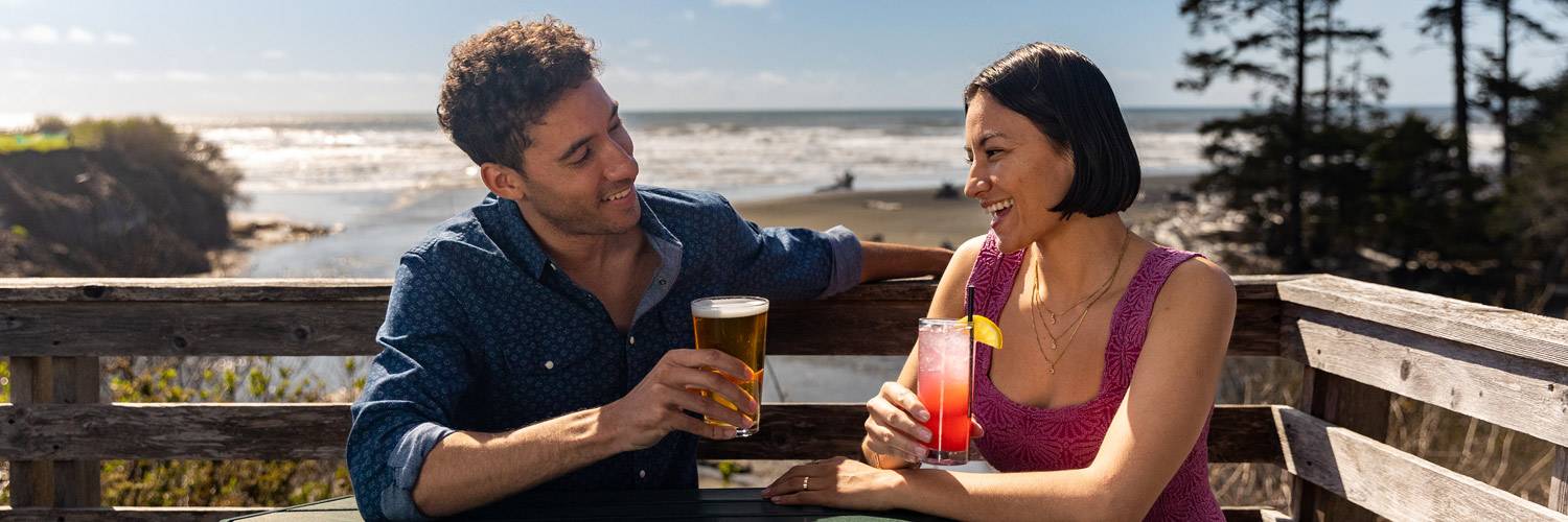 A couple enjoying drinks on the deck at Kalaloch Lodge