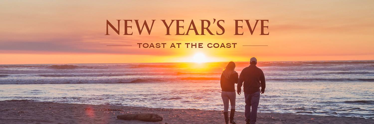 A couple walks along a beach at sunset with a New Year