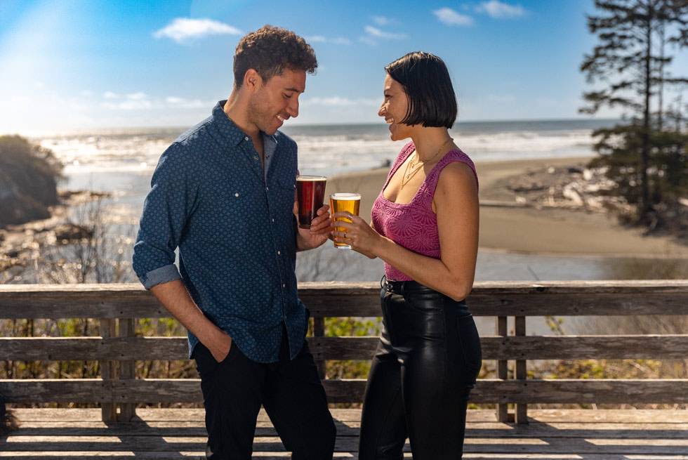 A couple having drinks on the deck at Kalaloch Lodge's Creekside Restaurant