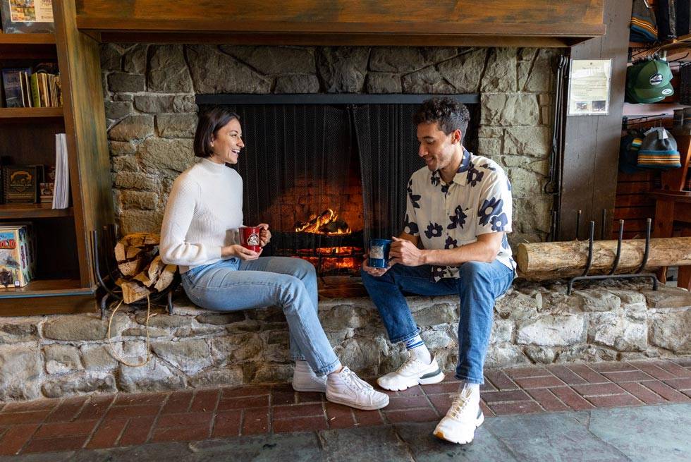 Two Kalaloch Lodge guests relaxing by the lobby fireplace